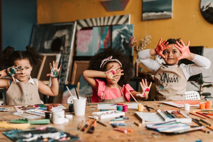 Kids laughing with paint-covered hands